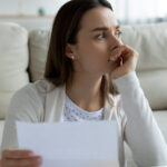 Femme lisant une lettre sérieuse.