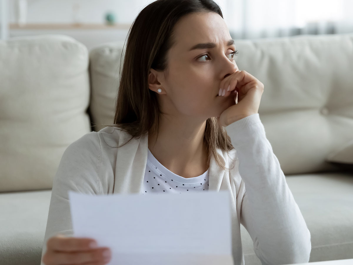 Femme lisant une lettre sérieuse.